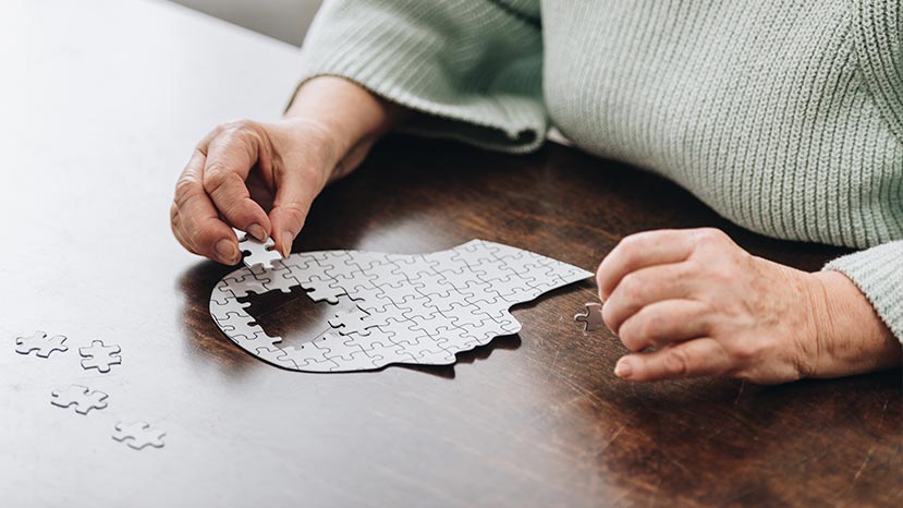 cropped view of senior woman playing with puzzles