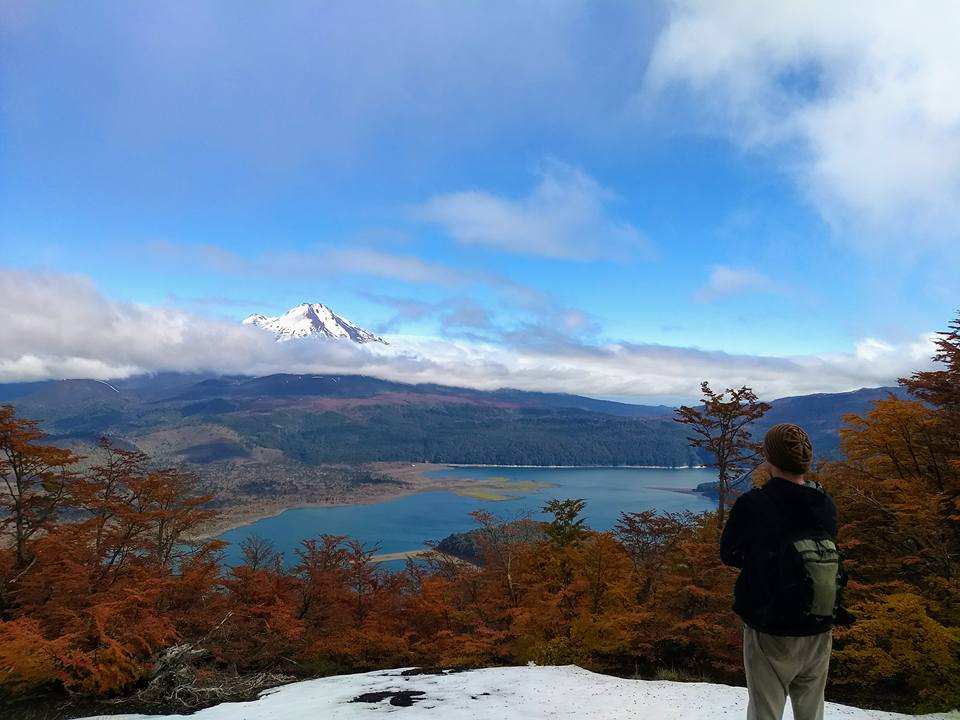 A man looking over a distant glacier covered in clouds