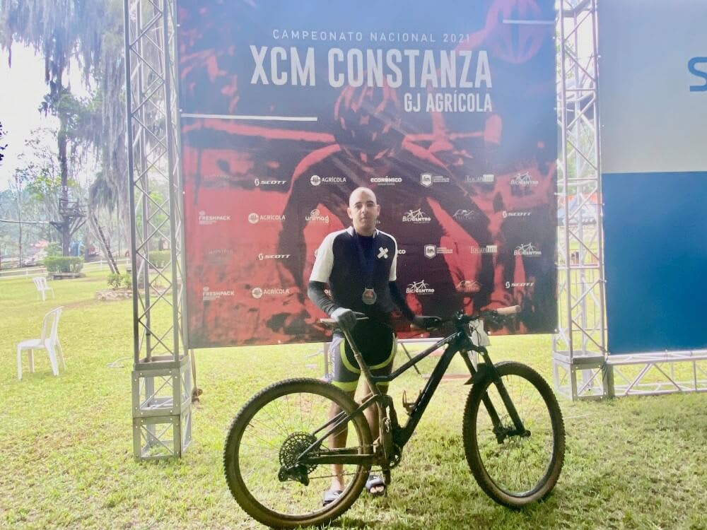 Carlos posing with his bike and a medal