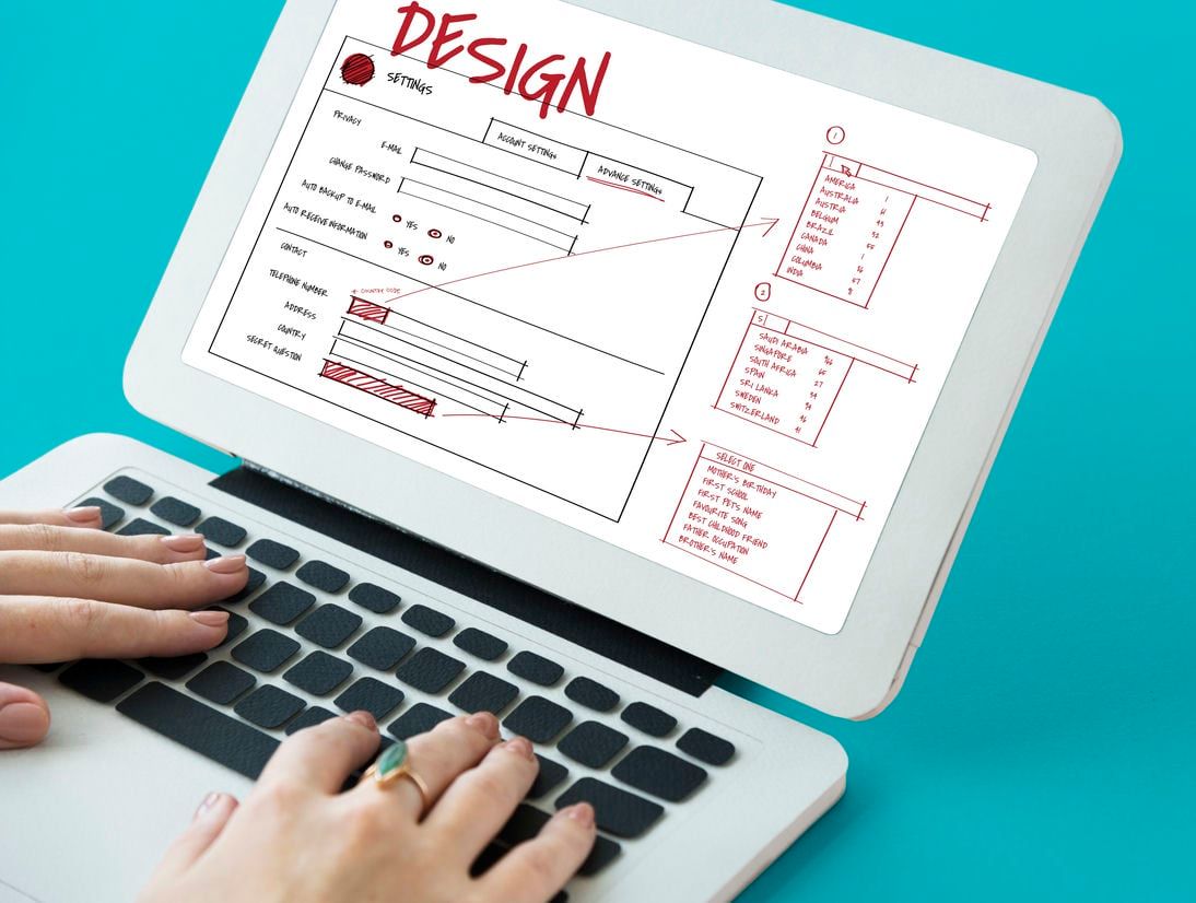 A person interacts with a laptop displaying a detailed design interface, highlighting the creative process in digital design.