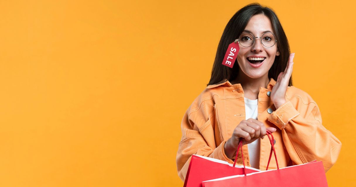 A joyful woman with a 'SALE' tag on her glasses holds a shopping bag, symbolizing exciting retail discounts.