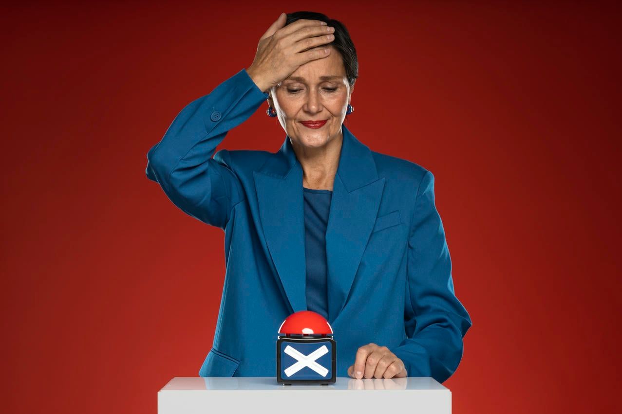 This image portrays a mature woman in a blue suit, expressing regret or disappointment as she presses a buzzer with a cross symbol, likely indicating a wrong answer or decision.