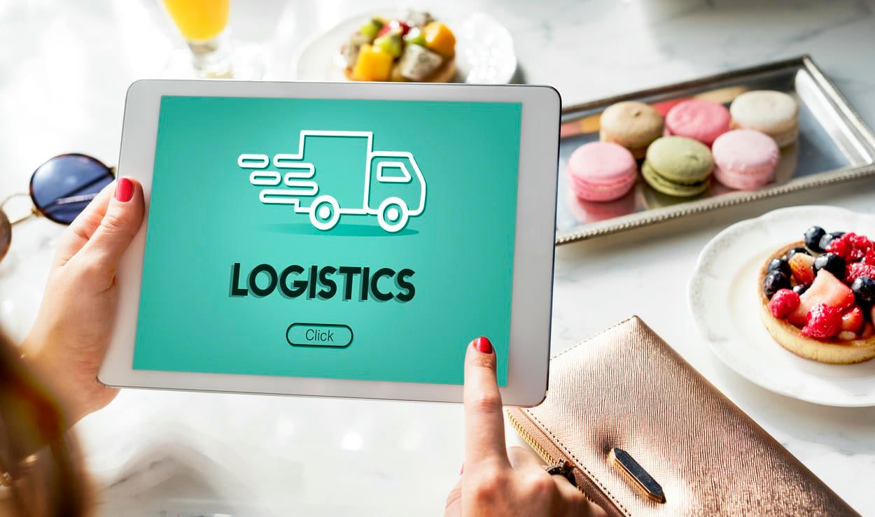 A person is using a tablet displaying a logistics application, symbolizing the modern, digital approach to managing supply chain operations.