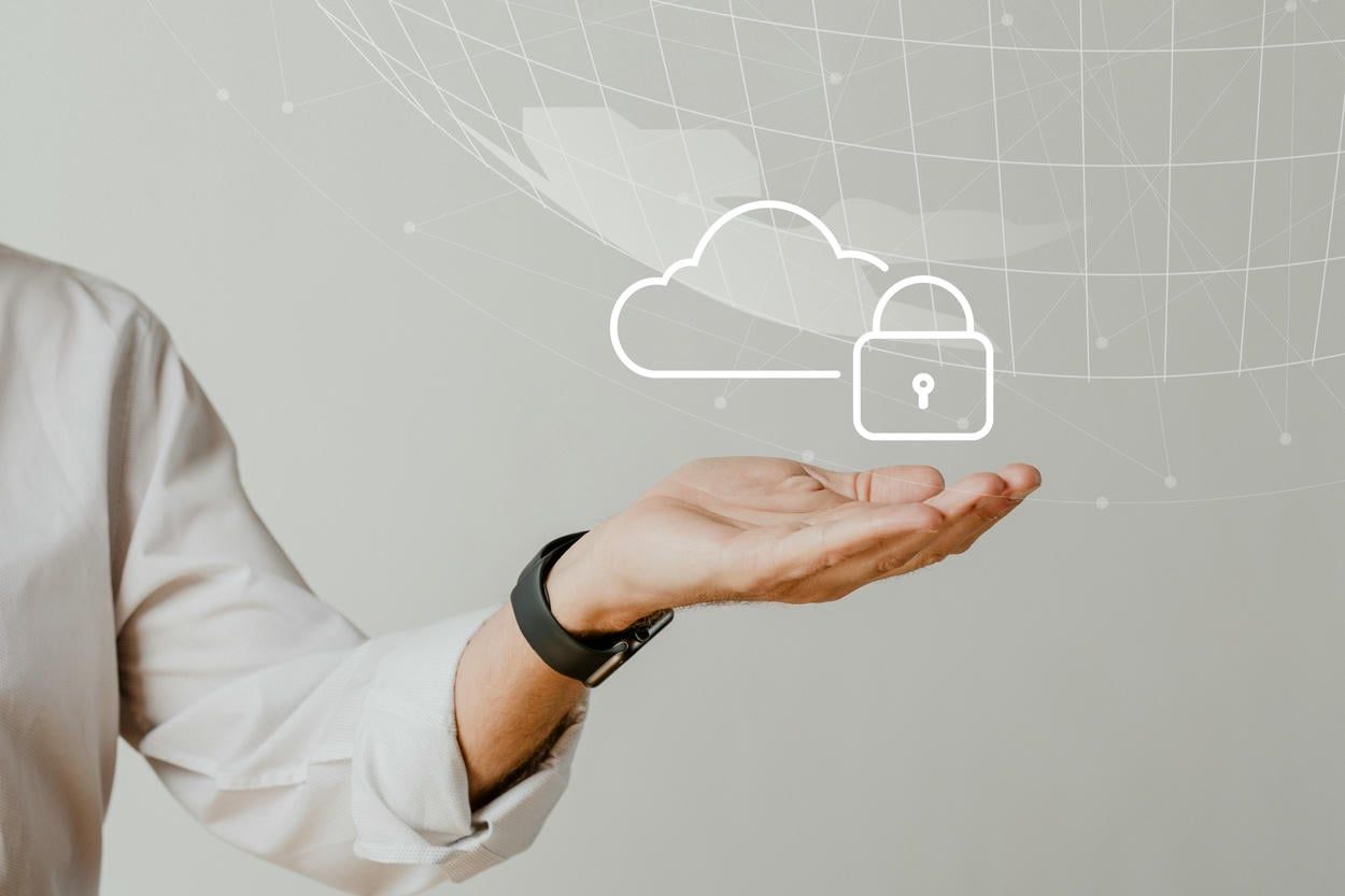 This image illustrates a person holding a digital cloud with a padlock icon, symbolizing data protection and secure cloud computing.