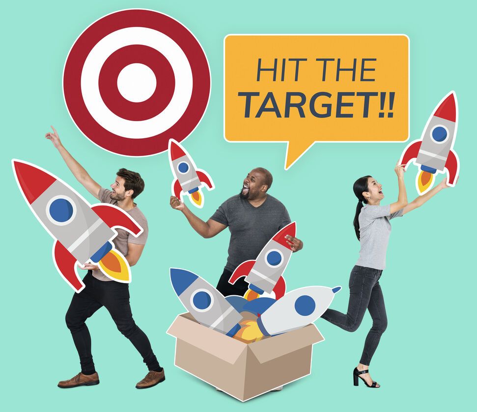 This image shows a diverse group of people with rockets, aiming for a target, symbolizing teamwork and goal achievement.
