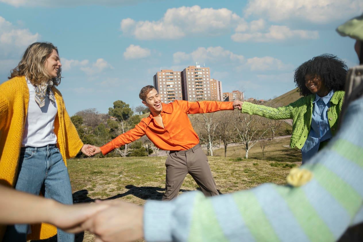 Friends spinning and holding hands in an outdoor field