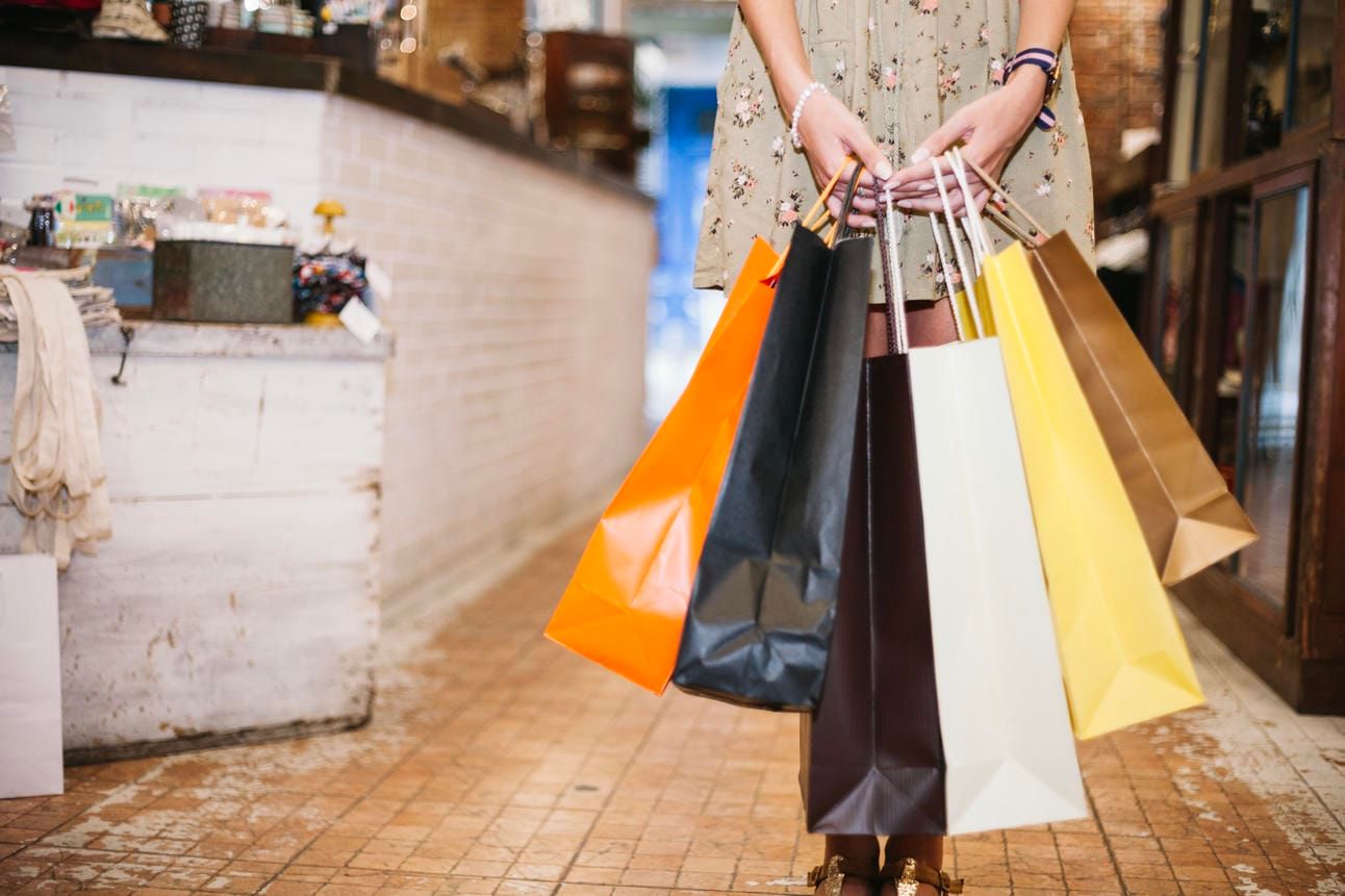 Woman holding bunch of paper bags