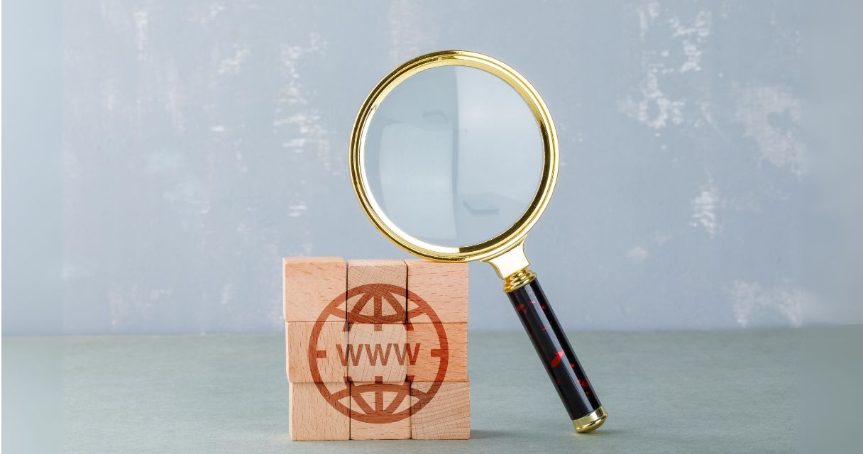 Conceptual of internet search with wooden blocks with internet icon, magnifying glass side view.