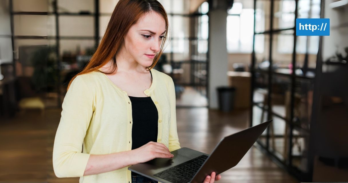 Attractive young woman working on laptop at workplace