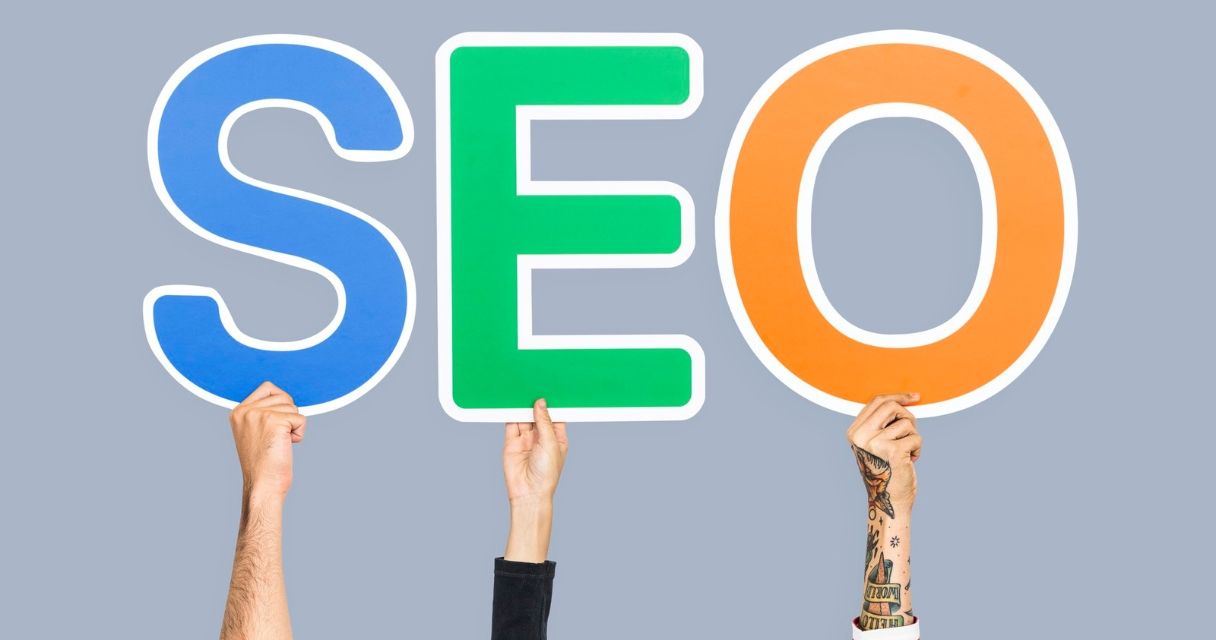 Hands holding up colorful letters forming the abbreviation SEO