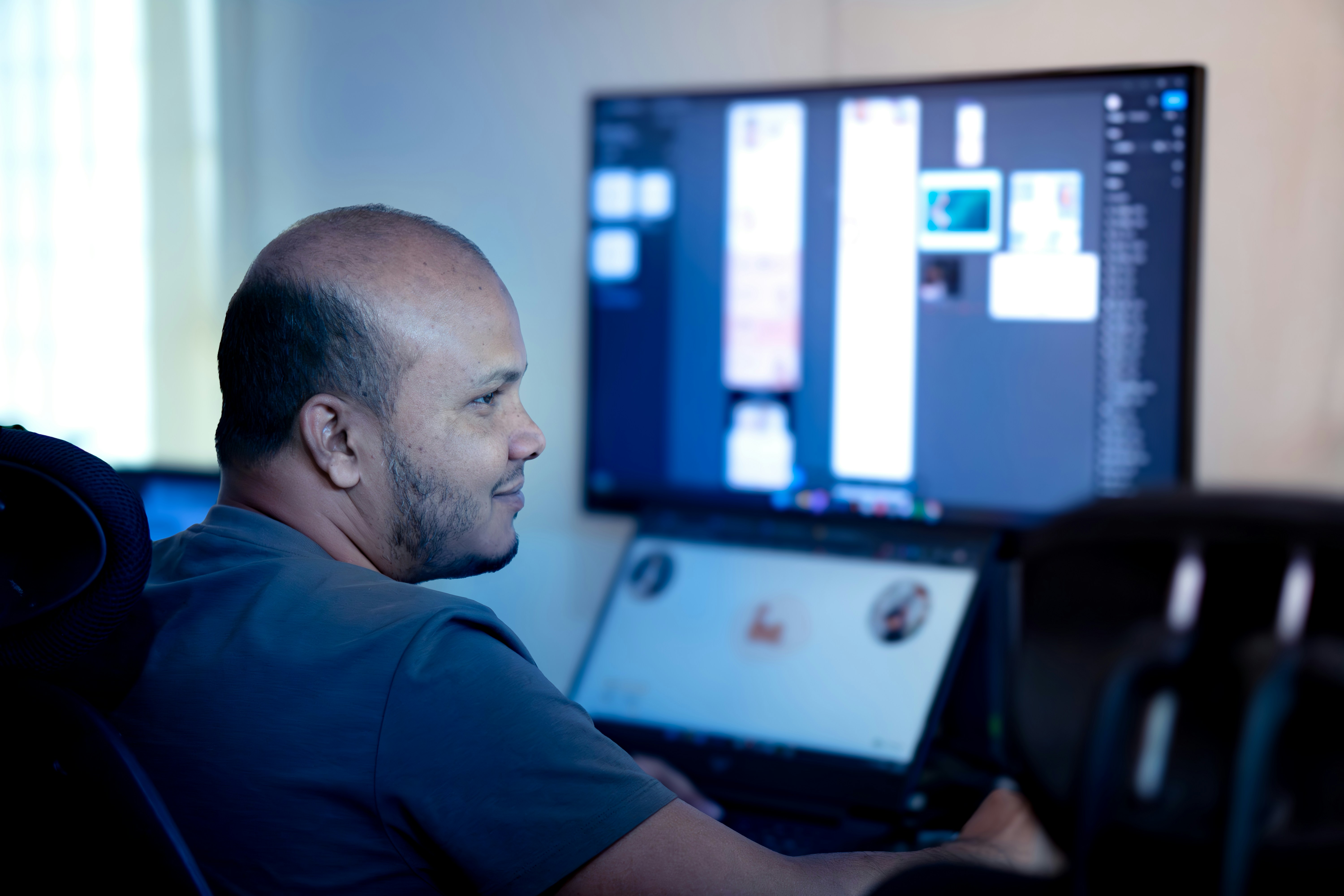 A designer reviewing interface components and test results on a monitor