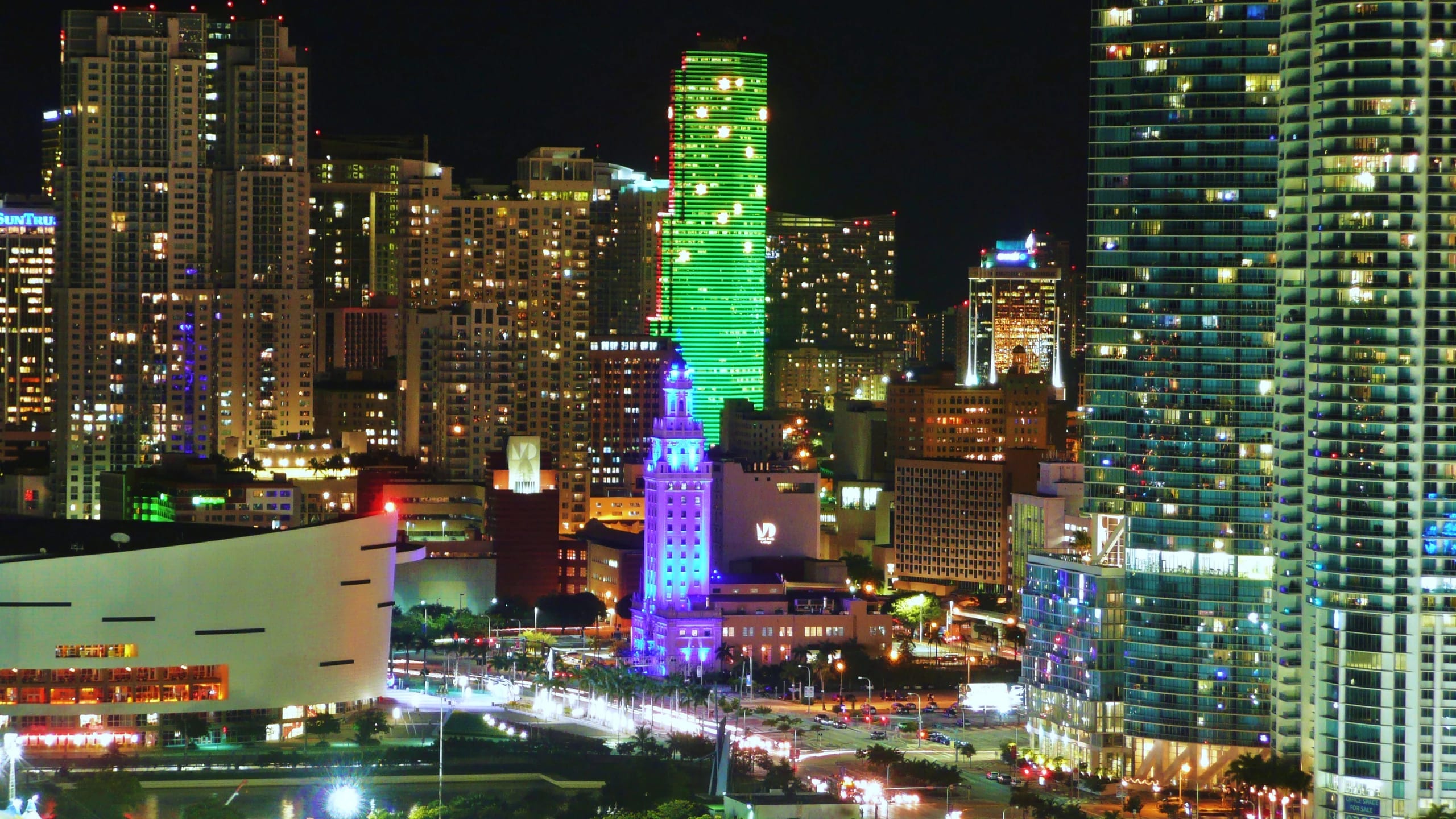 Biscayne Boulevard's skyline glowing green and blue at night