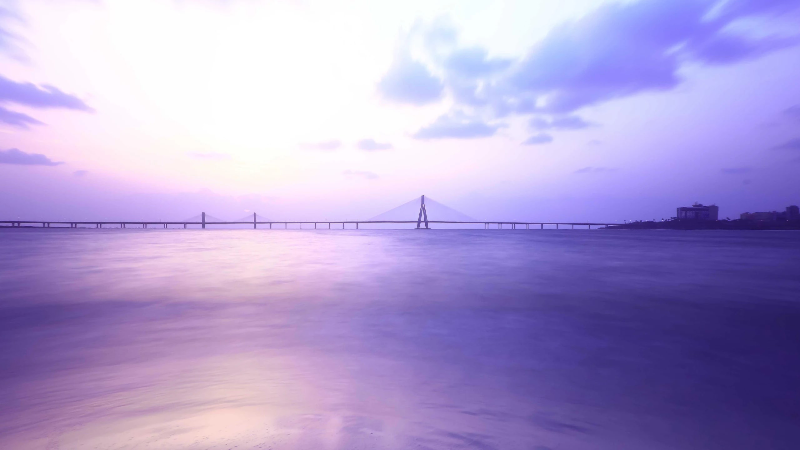 A purple dusk over the bay and a long bridge