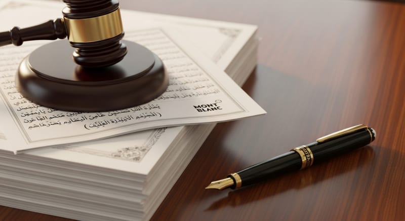 مطرقة قاضي وعقود قانونية تحتاج إلى مراجعة من مستشار قضايا عمالية محترف.