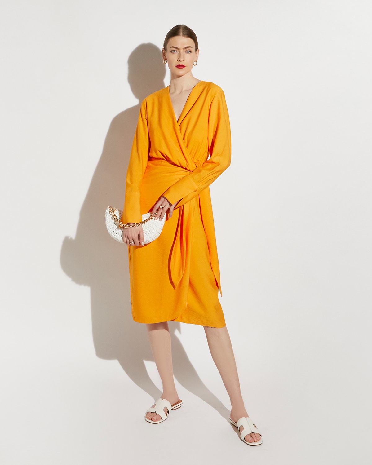 Model wearing our Dune Icon Loupe in orange and carrying our Dammi bag