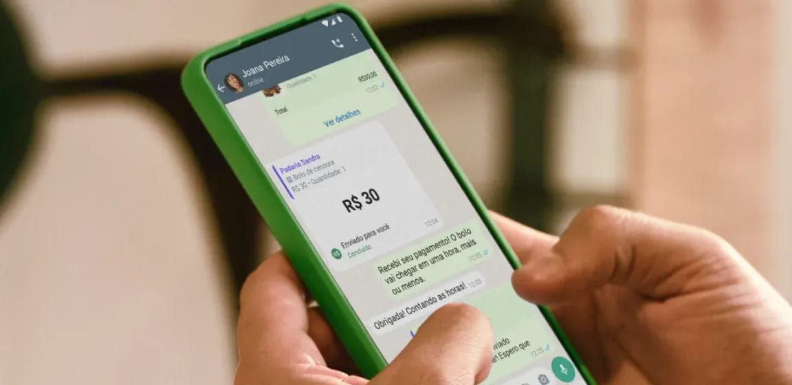 Uma mão digitando em uma conversa de whatsapp e confirmando sobre o pagamento do bolo