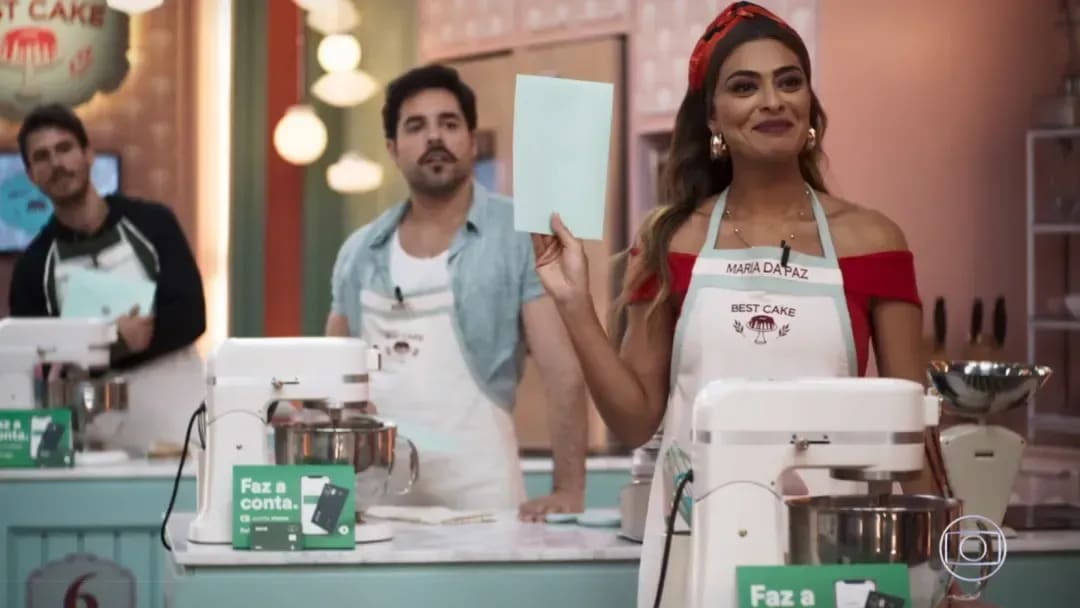 A imagem constam com 3 atores da novela A Dona do Pedaço e essas 3 pessoas estão em pé atrás das suas bancadas para participar de um programa chamado Best Cake da novela. Além disso, essa parceria foi marcada pelo lançamento da Conta Stone em 2019. 