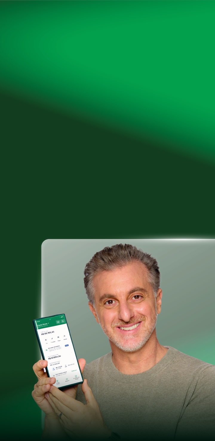 Luciano Huck segurando um celular com o aplicativo da Stone