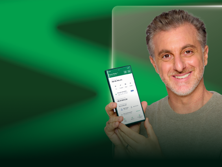 Luciano Huck segurando um celular com o aplicativo da Stone