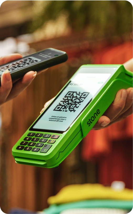 Empreendedor com a maquininha Stone e cliente utilizando o pagamento por QR Code