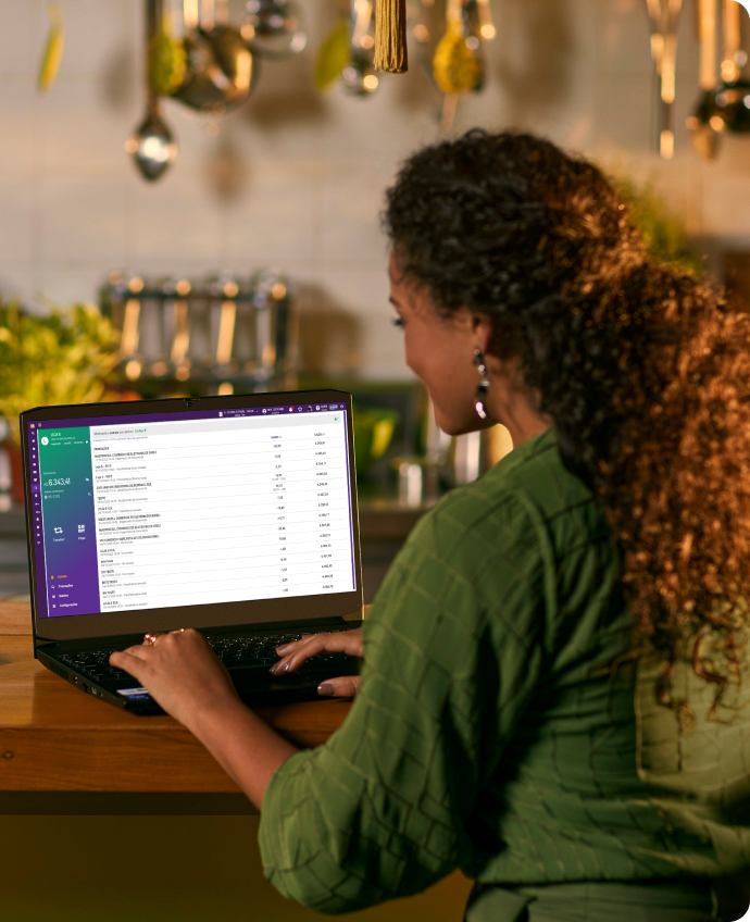 Mulher sentada usando um sistema da Linx em um notebook