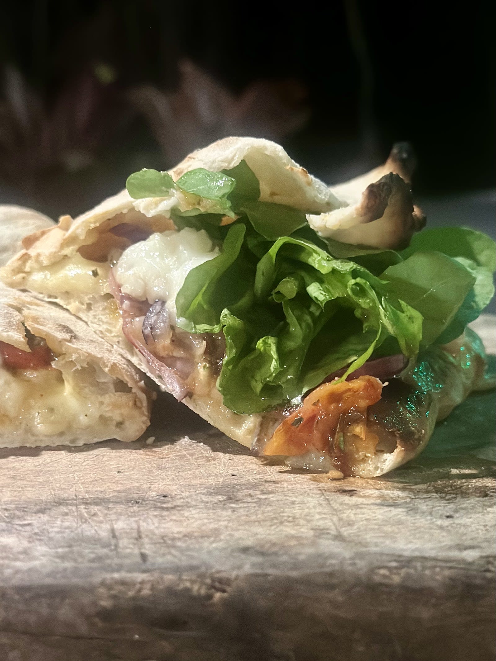 Detalhe de pizza do Benedetto Forno com borda dourada e recheio generoso
