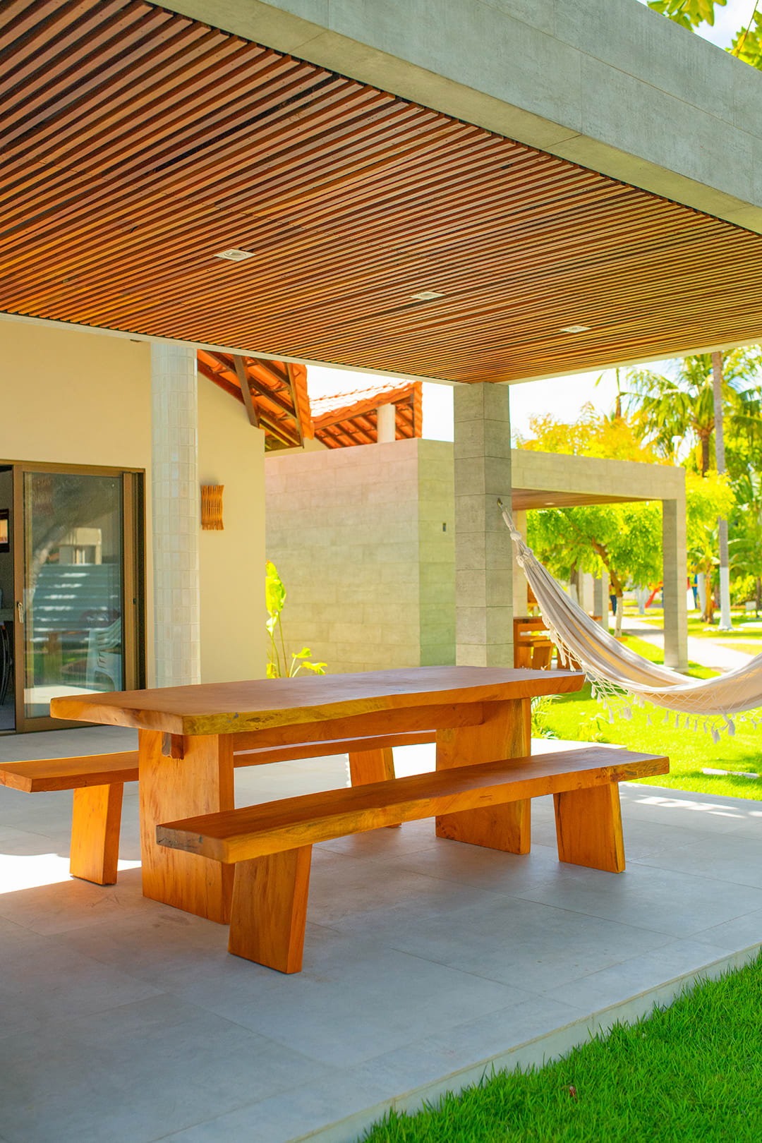 Varanda e área de lazer projetada pela Recife Arquitetos com paisagismo integrado