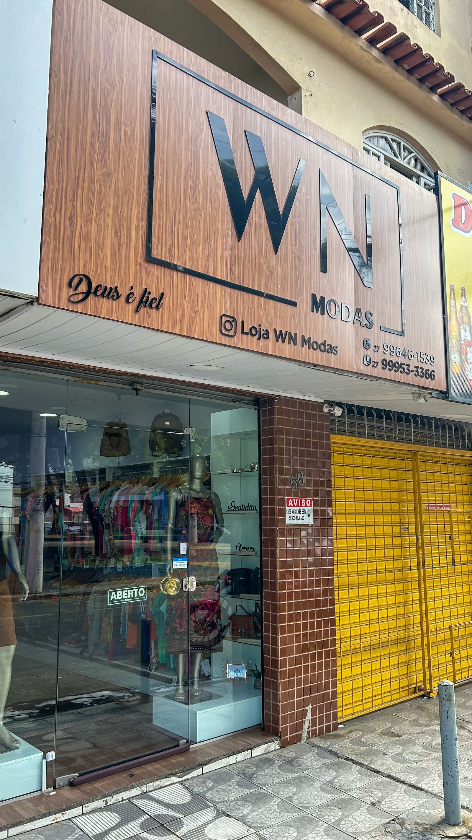 Peças femininas e masculinas na vitrine da WN Modas, em Cariacica, ES