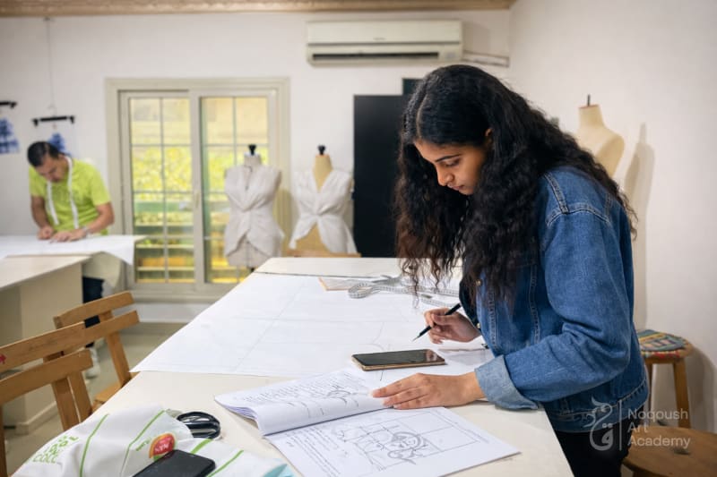 Pattern drafting class - student using curve ruler Noqoush Academy