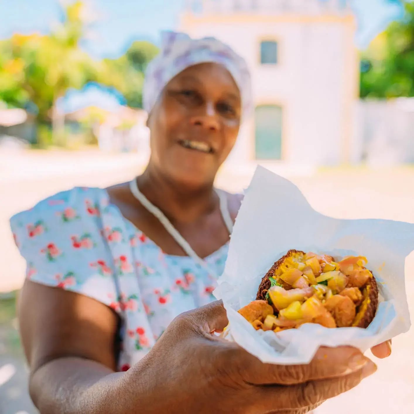 A cook holding a plate of Southern fried food outdoors