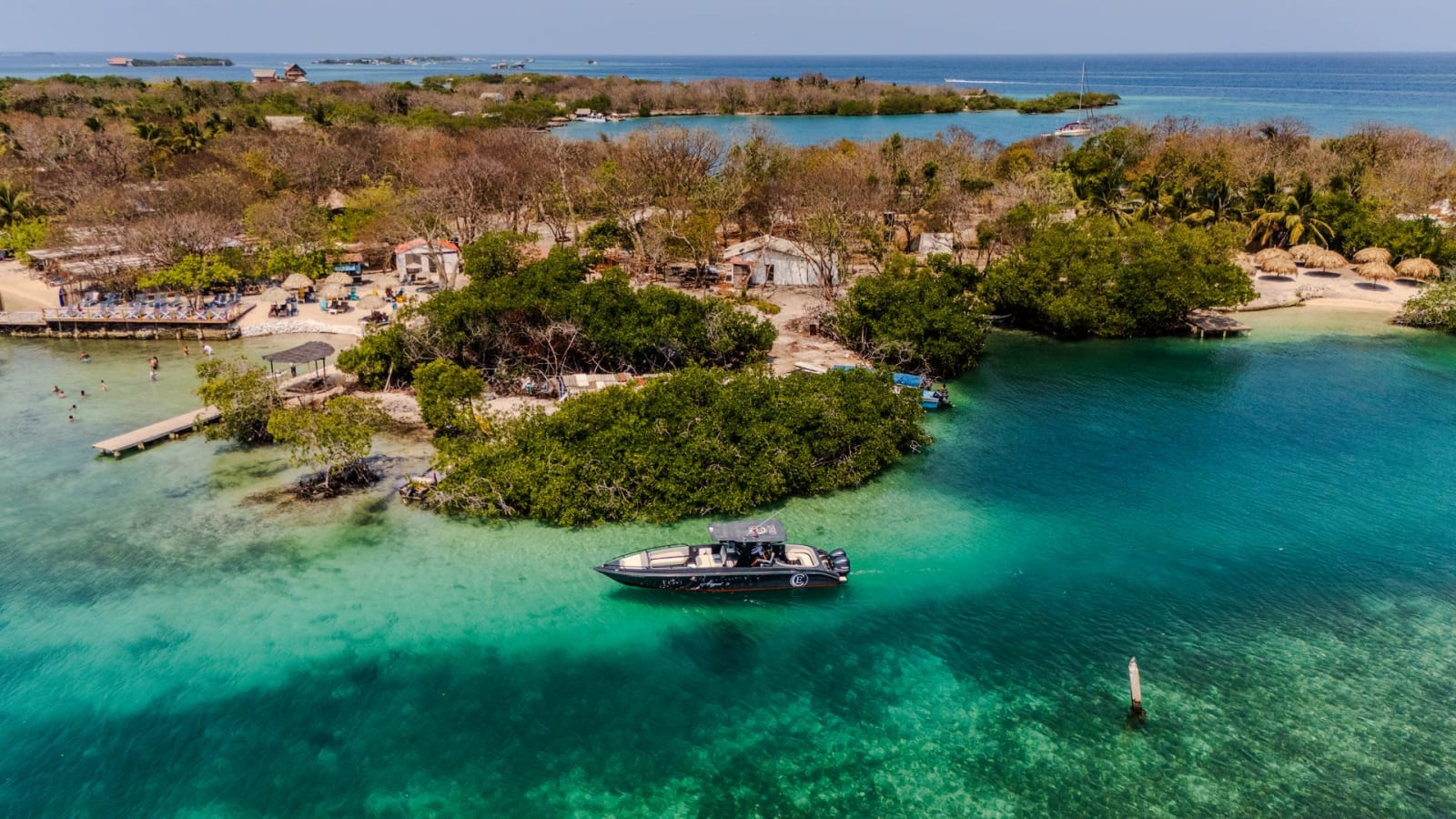 Lancha privada fondeada en aguas turquesas frente a una isla de manglar cerca de Cartagena
