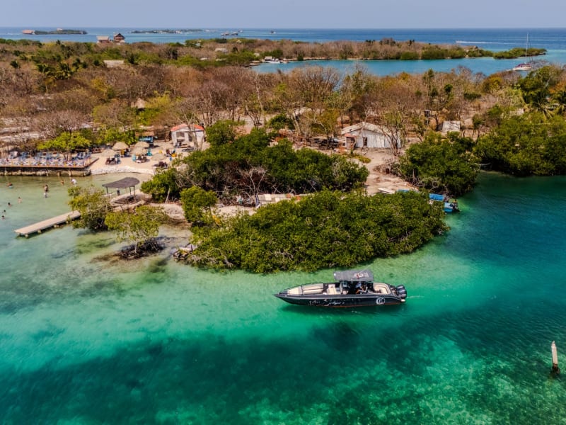 Lancha privada fondeada en aguas turquesas frente a una isla de manglar cerca de Cartagena