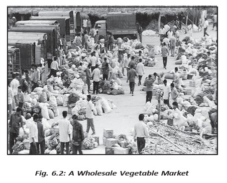 A wholesale vegetable market showing the buying and selling of produce.