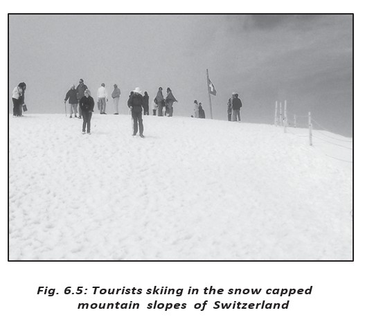 Tourists skiing on snow-covered mountain slopes in Switzerland; tourism provides tertiary-sector services.