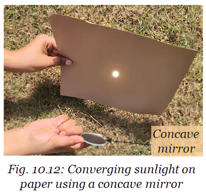 A concave mirror focuses sunlight to form a bright spot on paper.