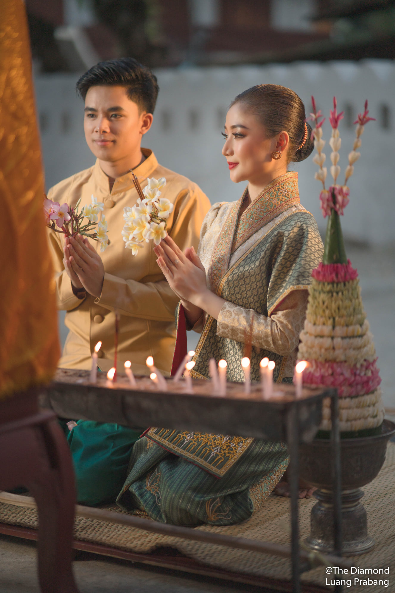 Couple participating in a traditional candle offering ceremony in Luang Prabang, reflecting respectful cultural participation. Couple participating in a traditional candle offering ceremony in Luang Prabang, reflecting respectful cultural participation.