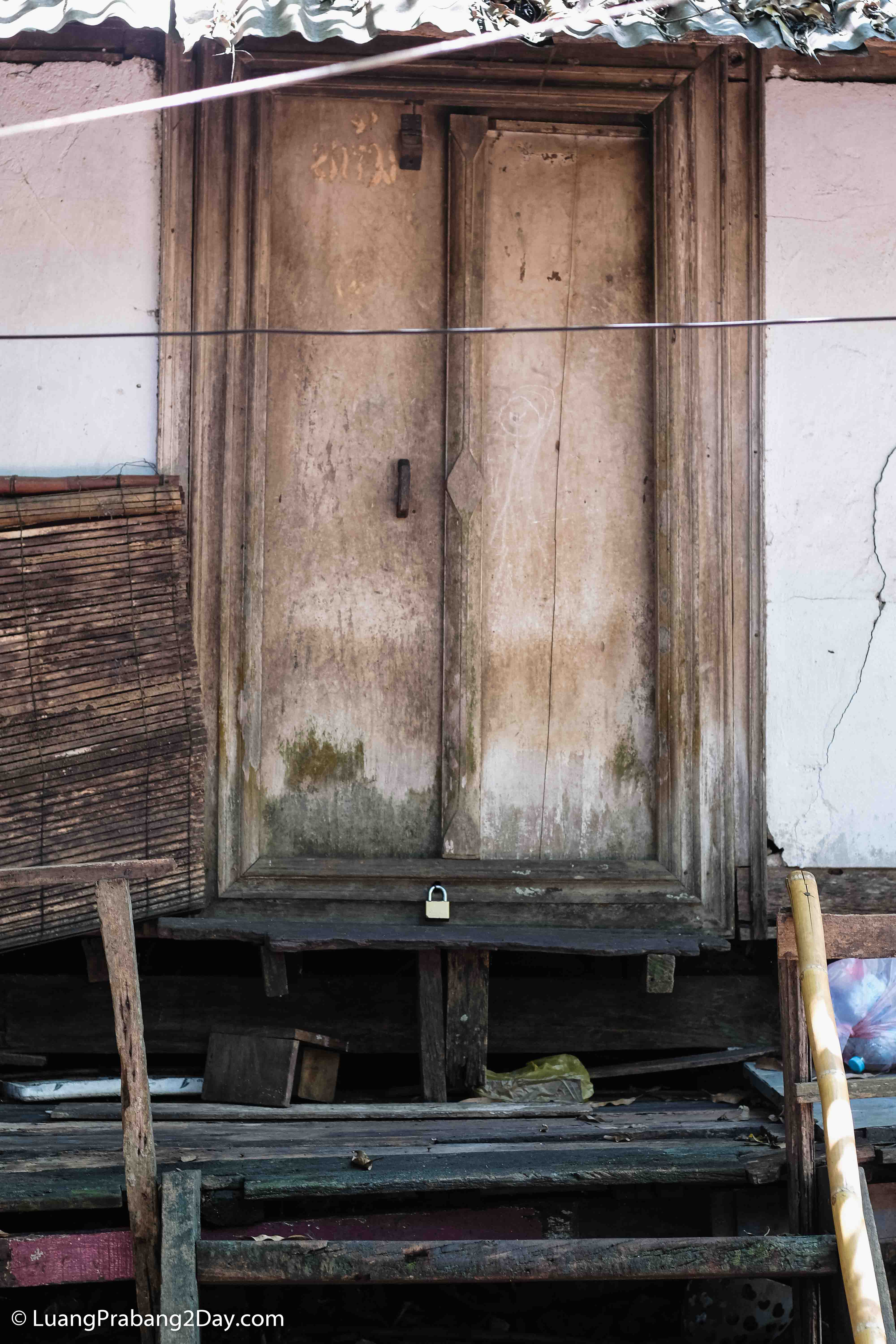 A continuous row of traditional wooden doors illustrating the architectural rhythm of Luang Prabang's historic streetscape. A continuous row of traditional wooden doors illustrating the architectural rhythm of Luang Prabang's historic streetscape.