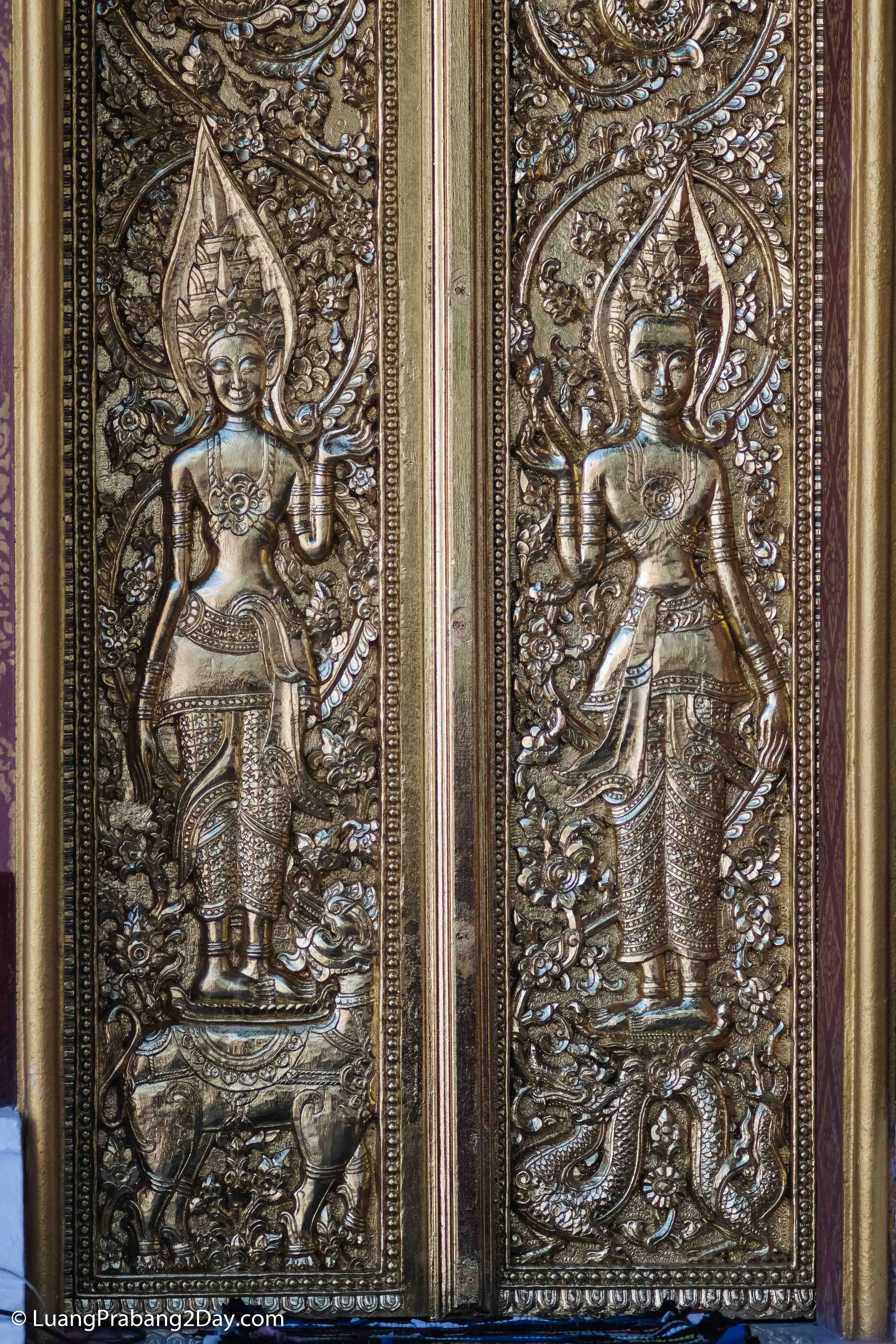 Golden temple window framed by richly decorated columns and traditional Buddhist motifs in Luang Prabang. Golden temple window framed by richly decorated columns and traditional Buddhist motifs in Luang Prabang.
