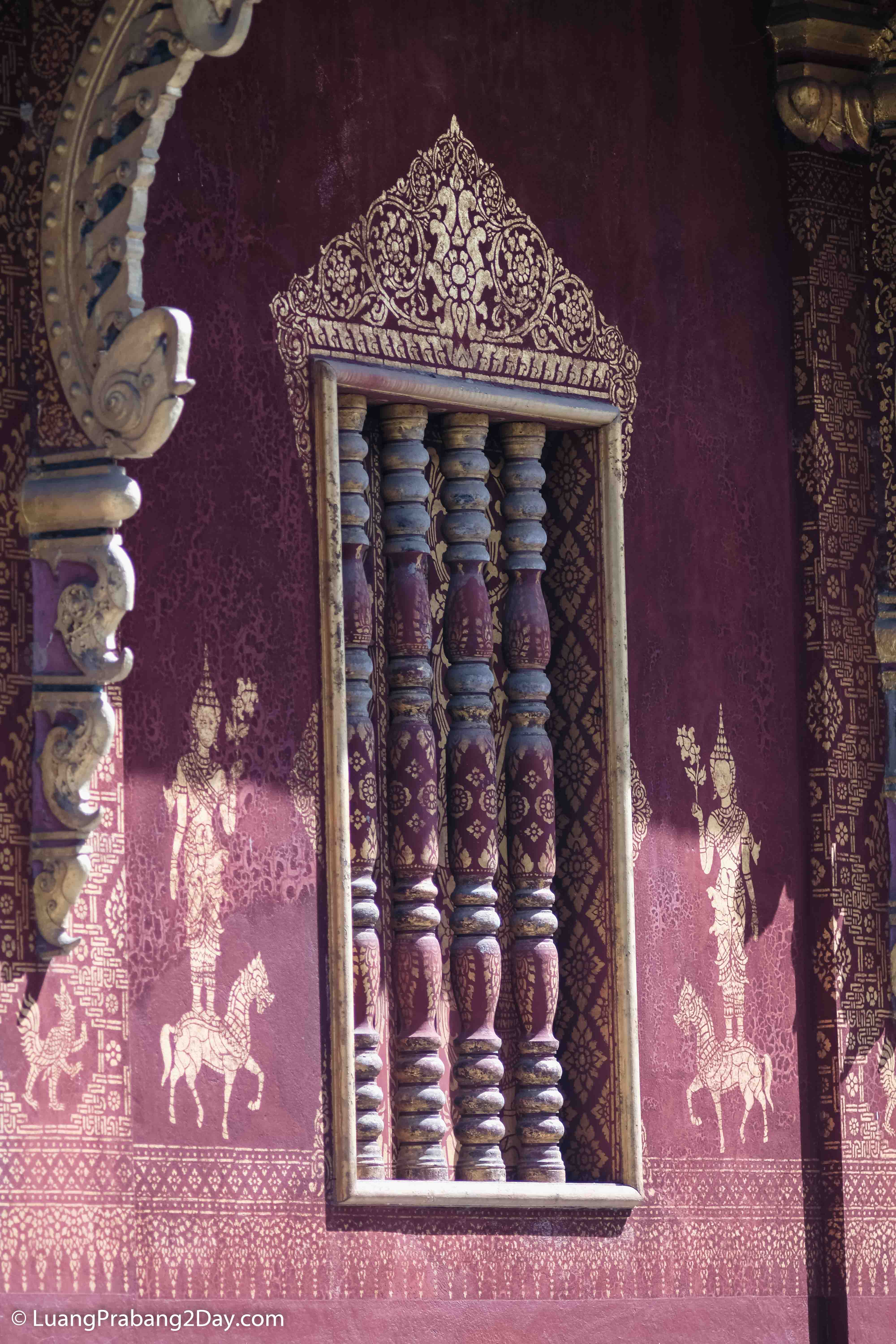 Ornamental temple window surrounded by painted walls and traditional Lao decorative patterns. Ornamental temple window surrounded by painted walls and traditional Lao decorative patterns.