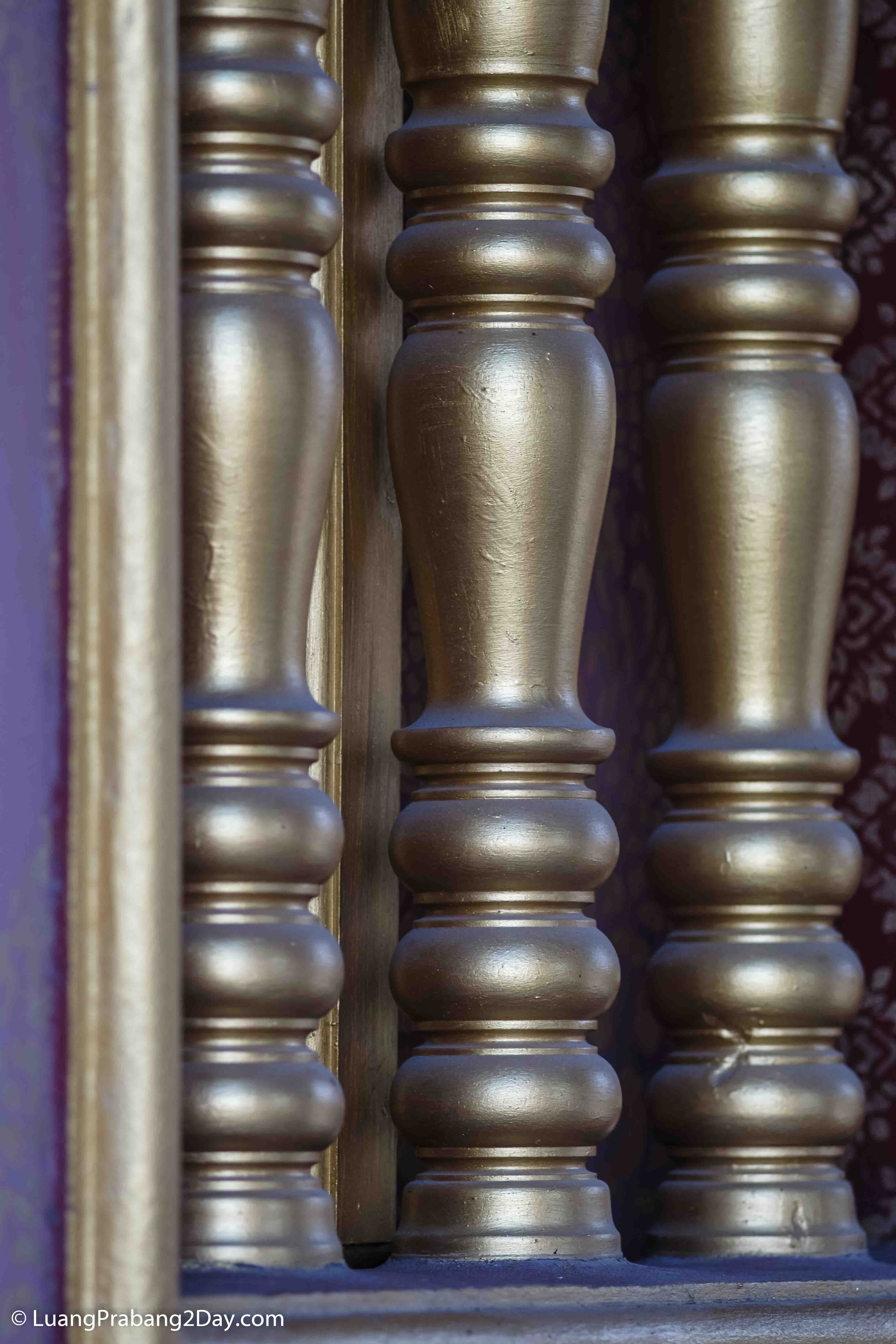 Close-up of gilded wooden columns revealing the refined craftsmanship of a Buddhist temple window. Close-up of gilded wooden columns revealing the refined craftsmanship of a Buddhist temple window.