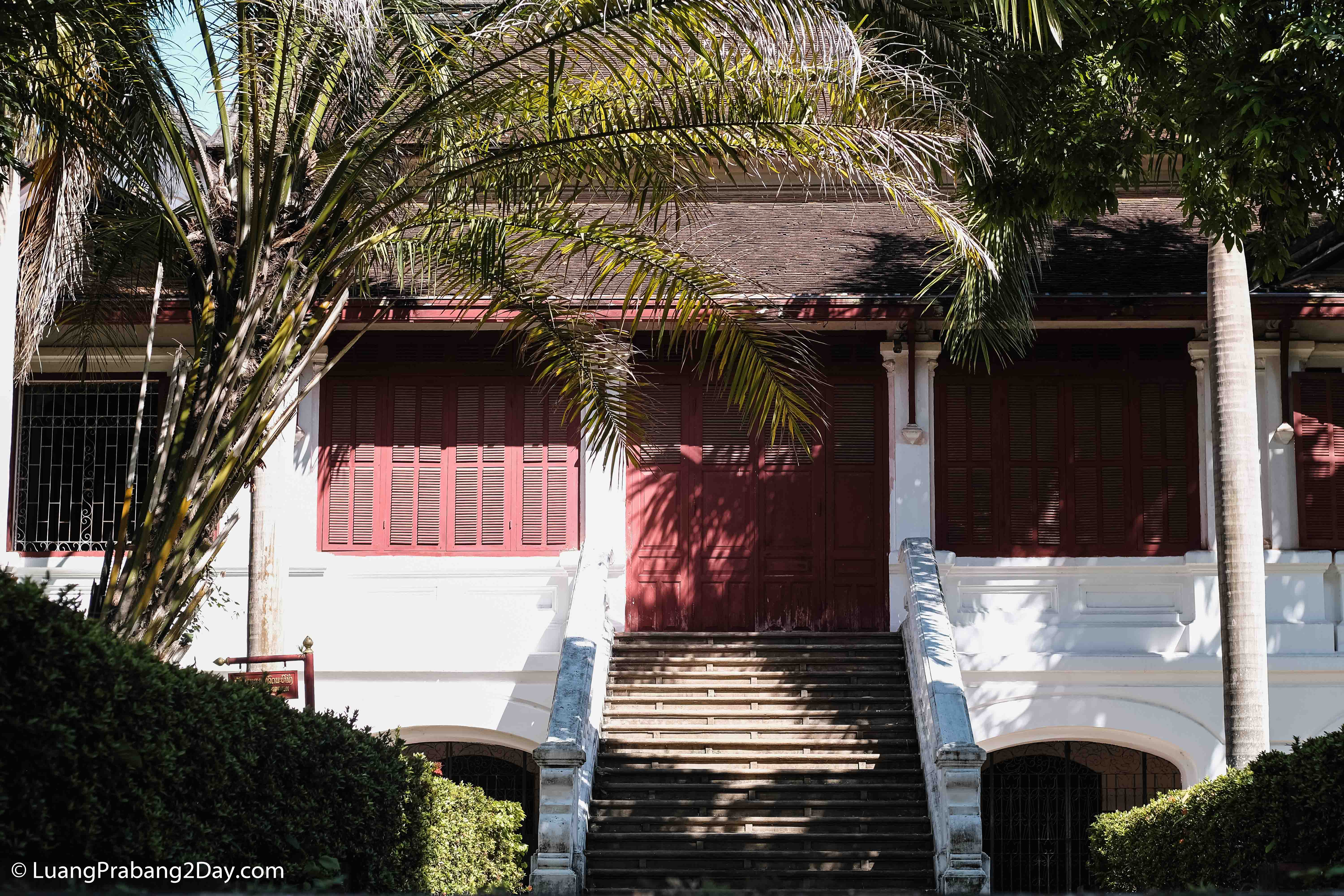 Historic colonial residence with symmetrical wooden shutters and central staircase in Luang Prabang's UNESCO World Heritage district. Historic colonial residence with symmetrical wooden shutters and central staircase in Luang Prabang's UNESCO World Heritage district.