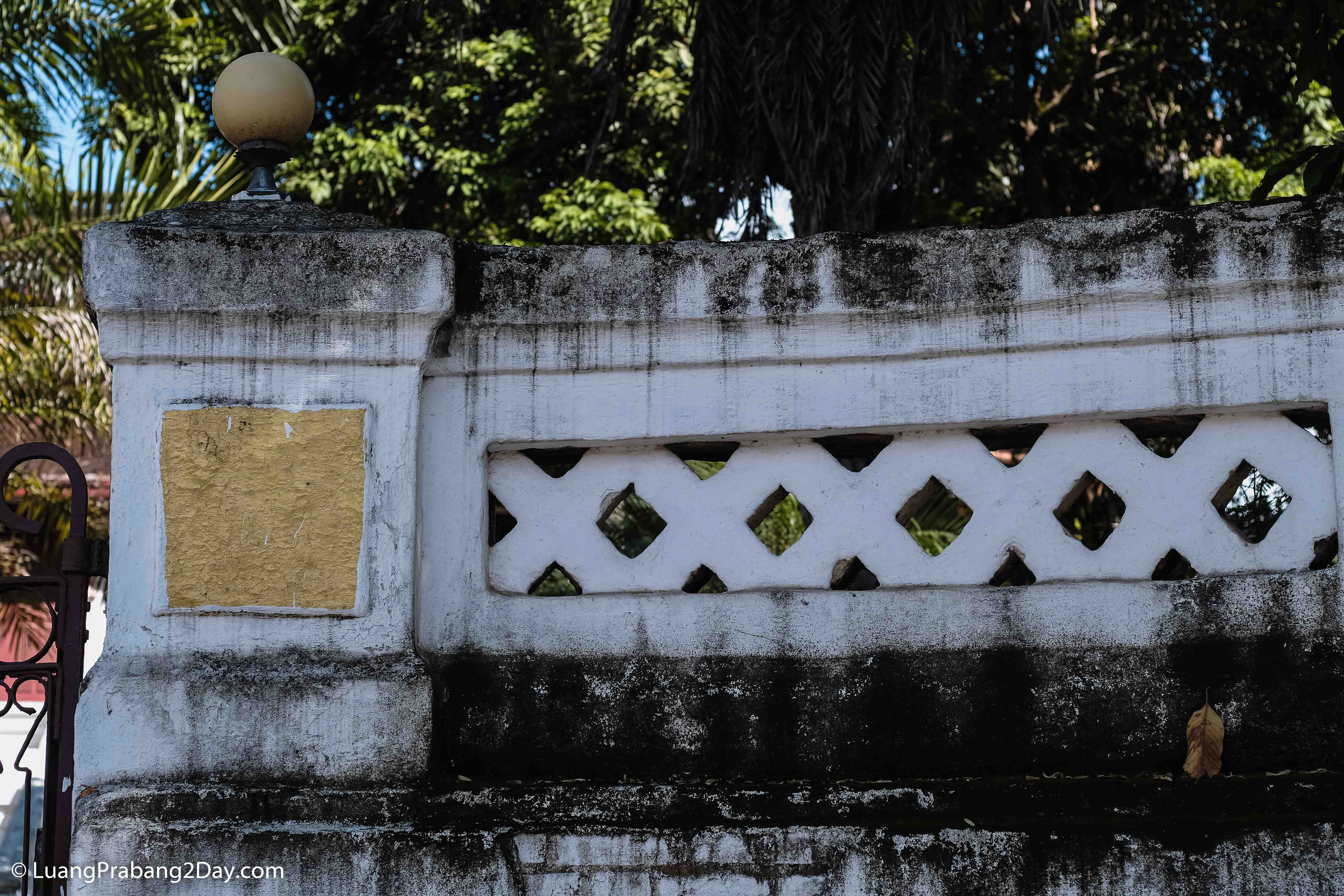 Historic masonry wall featuring geometric ventilation openings characteristic of traditional Lao architecture. Historic masonry wall featuring geometric ventilation openings characteristic of traditional Lao architecture.