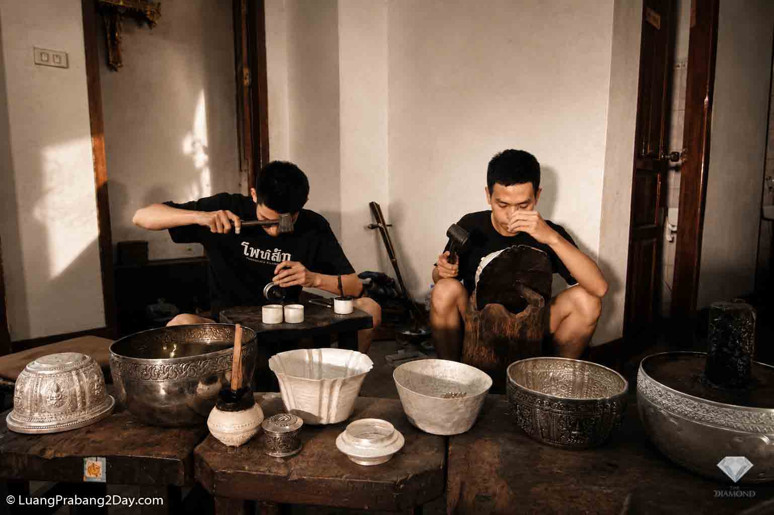 Traditional Lan Xang silversmiths handcraft ceremonial silver vessels using inherited engraving techniques inside a family workshop in Luang Prabang. Traditional Lan Xang silversmiths handcraft ceremonial silver vessels using inherited engraving techniques inside a family workshop in Luang Prabang.
