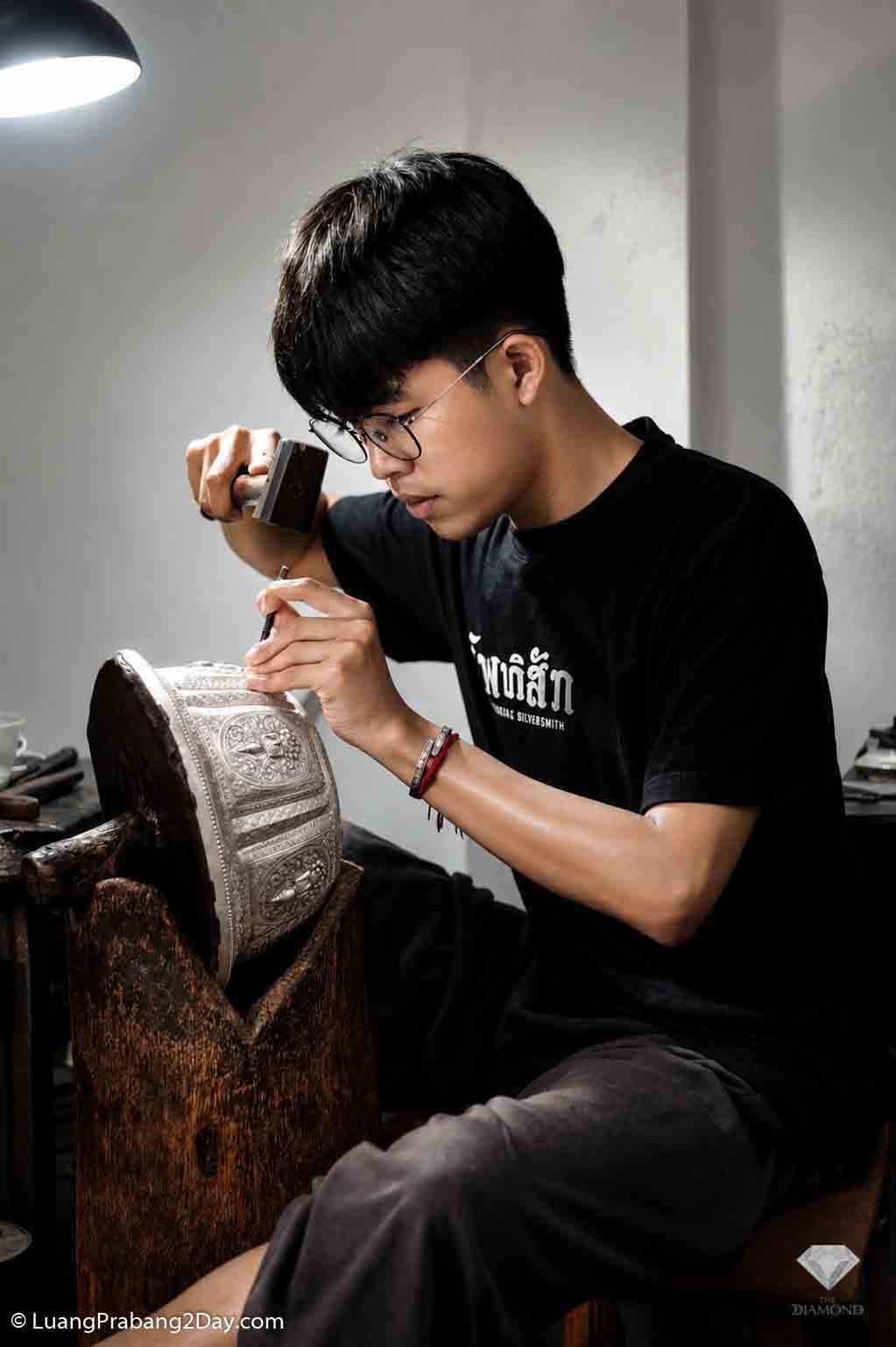 Young Lao silversmith handcrafting traditional silverware in Luang Prabang Young Lao silversmith handcrafting traditional silverware in Luang Prabang