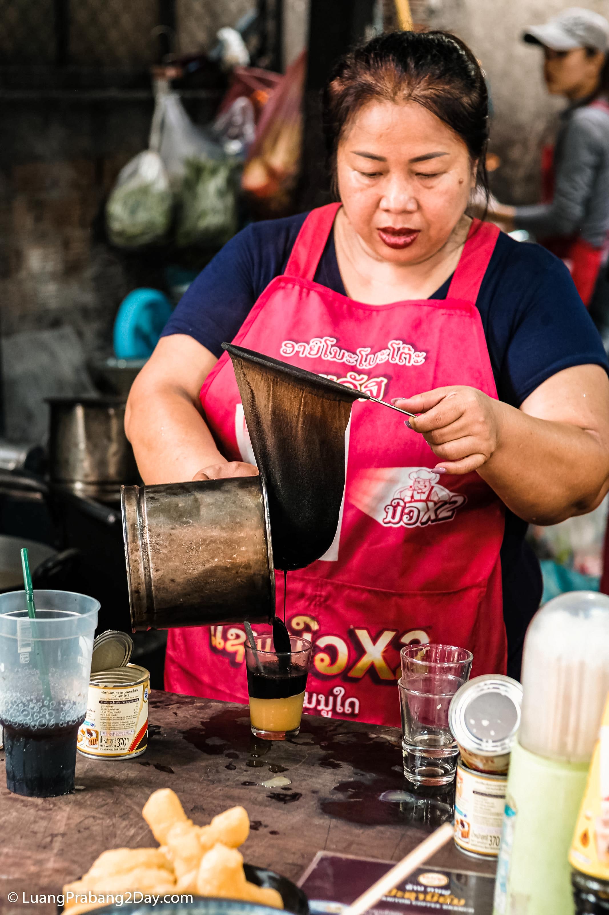 Local coffee vendor preparing traditional Lao coffee in Luang Prabang Local coffee vendor preparing traditional Lao coffee in Luang Prabang