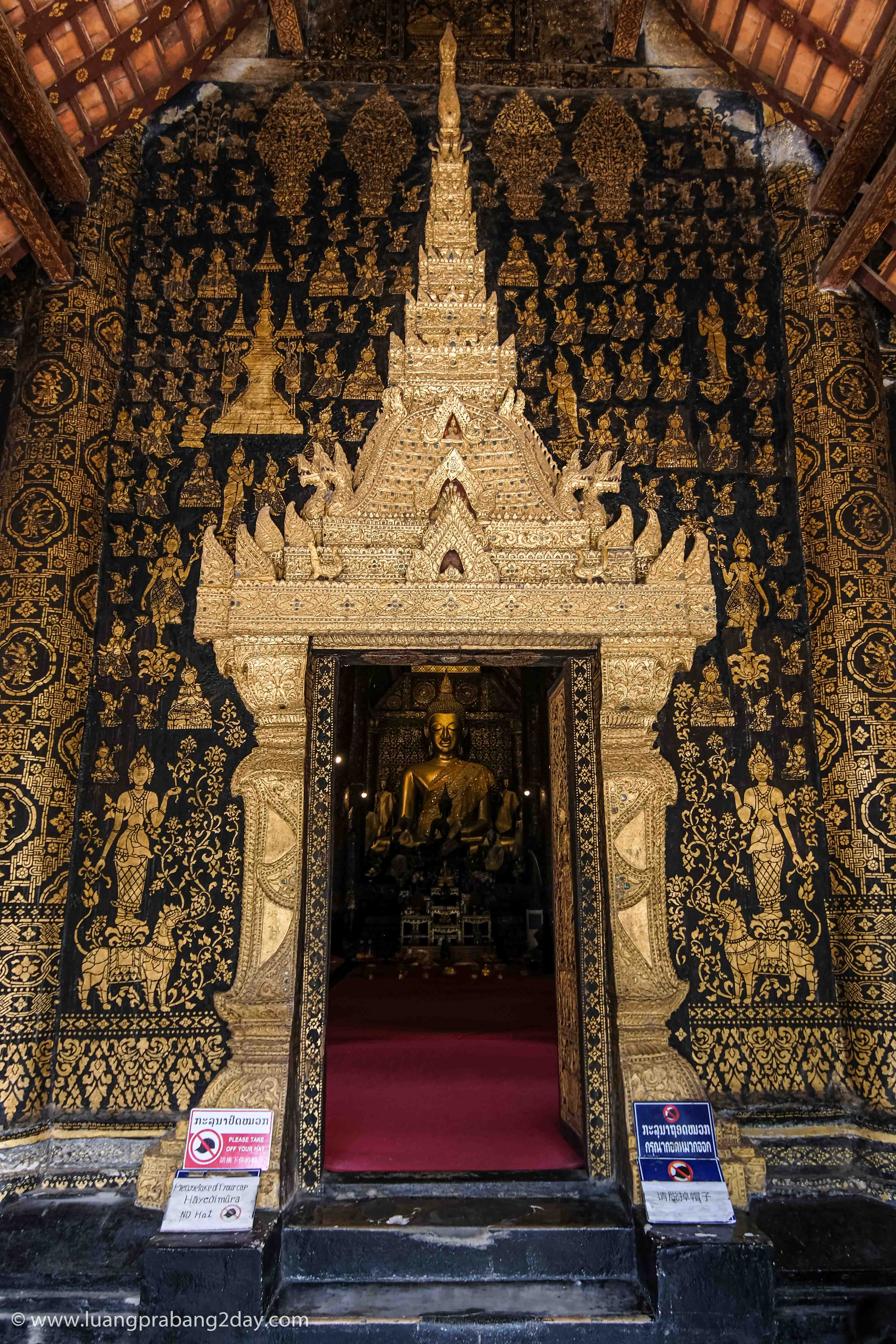 Entrance doorway of Wat Xieng Thong decorated with black lacquer and gilded celestial figures. Entrance doorway of Wat Xieng Thong decorated with black lacquer and gilded celestial figures.