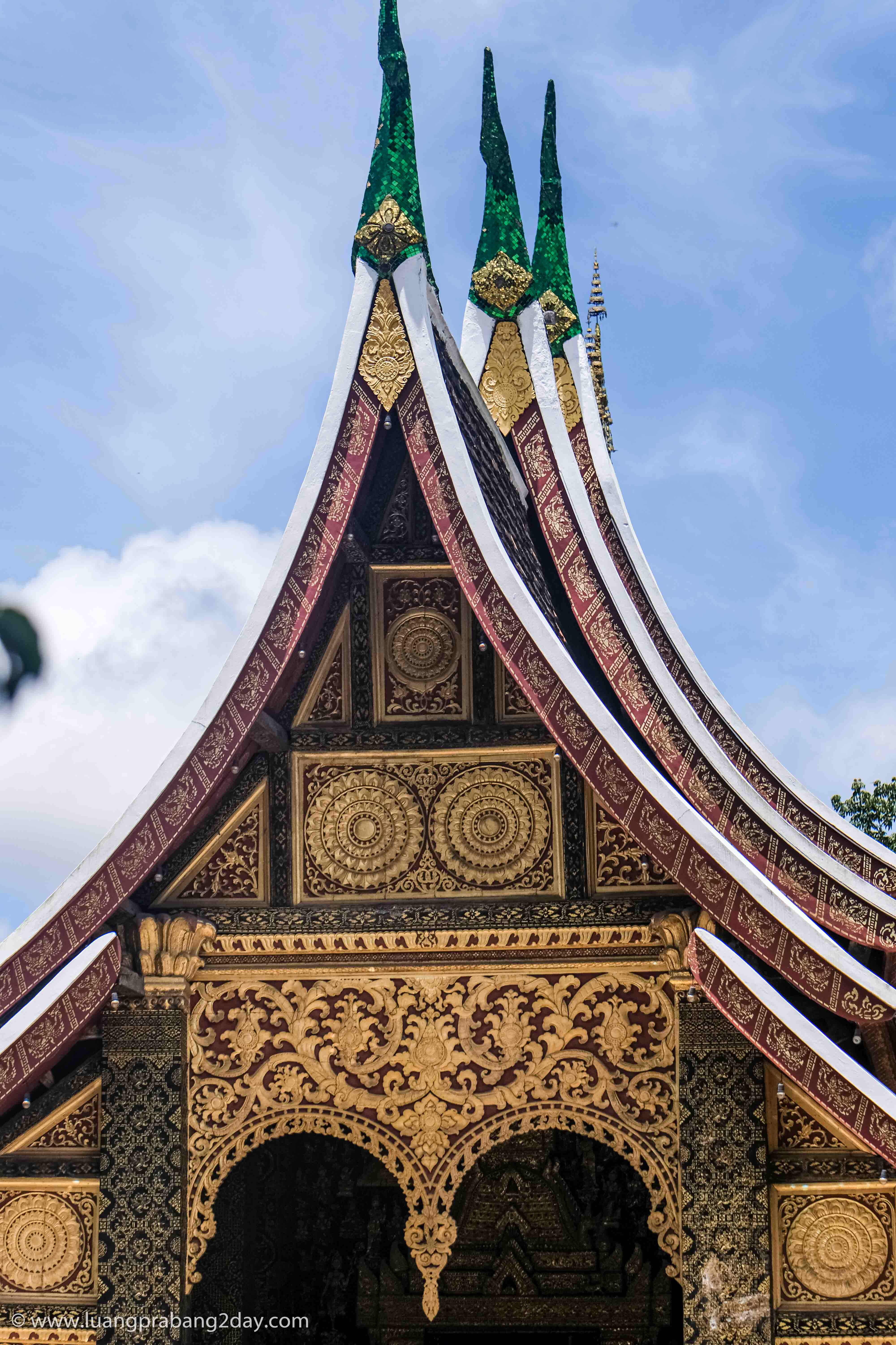 Decorated roof gable of Wat Xieng Thong featuring intricate gilded wood carvings. Decorated roof gable of Wat Xieng Thong featuring intricate gilded wood carvings.