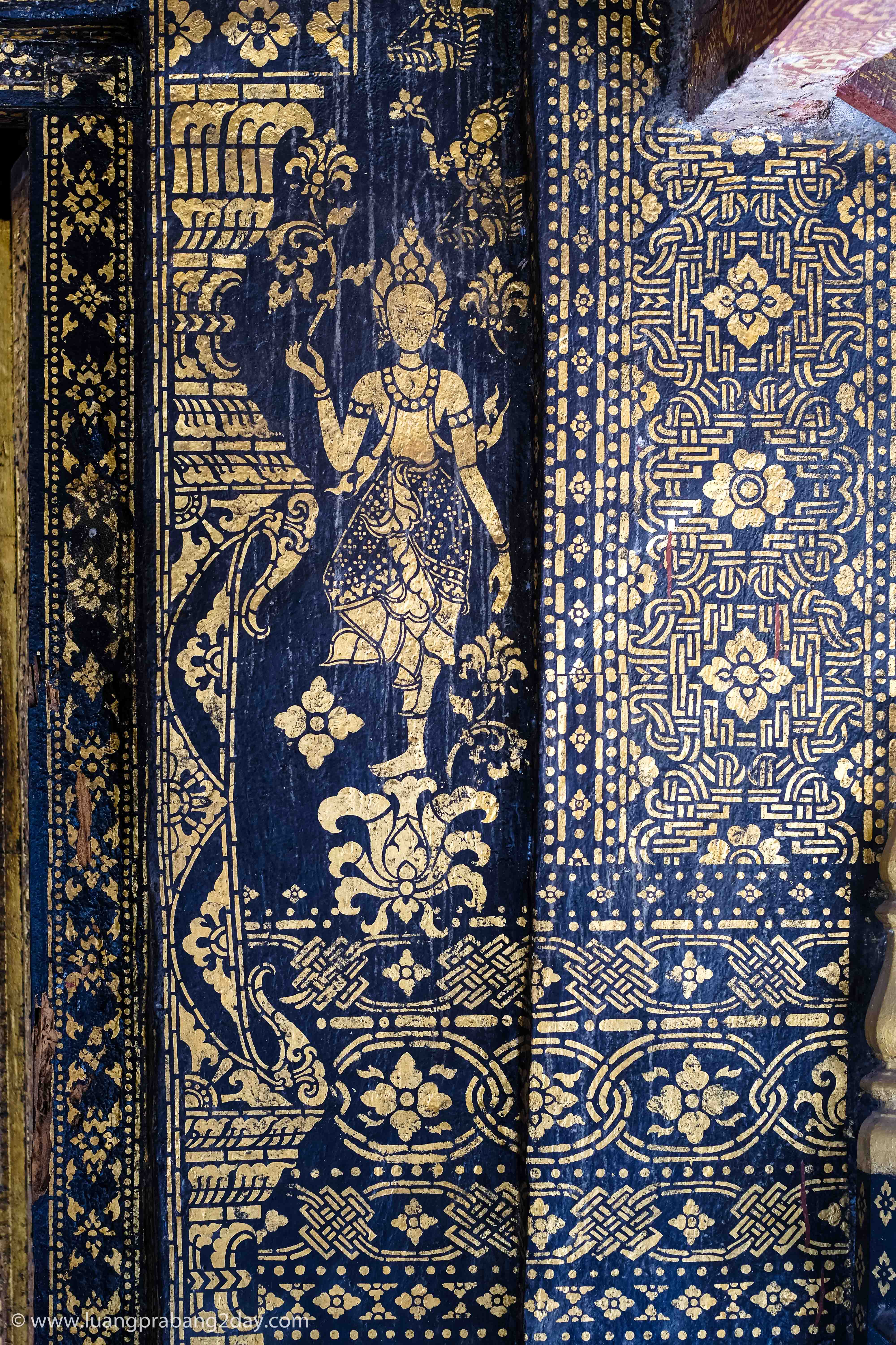 Decorated interior wall combining black lacquer, gold leaf, and traditional Lao ornamental patterns. Decorated interior wall combining black lacquer, gold leaf, and traditional Lao ornamental patterns.