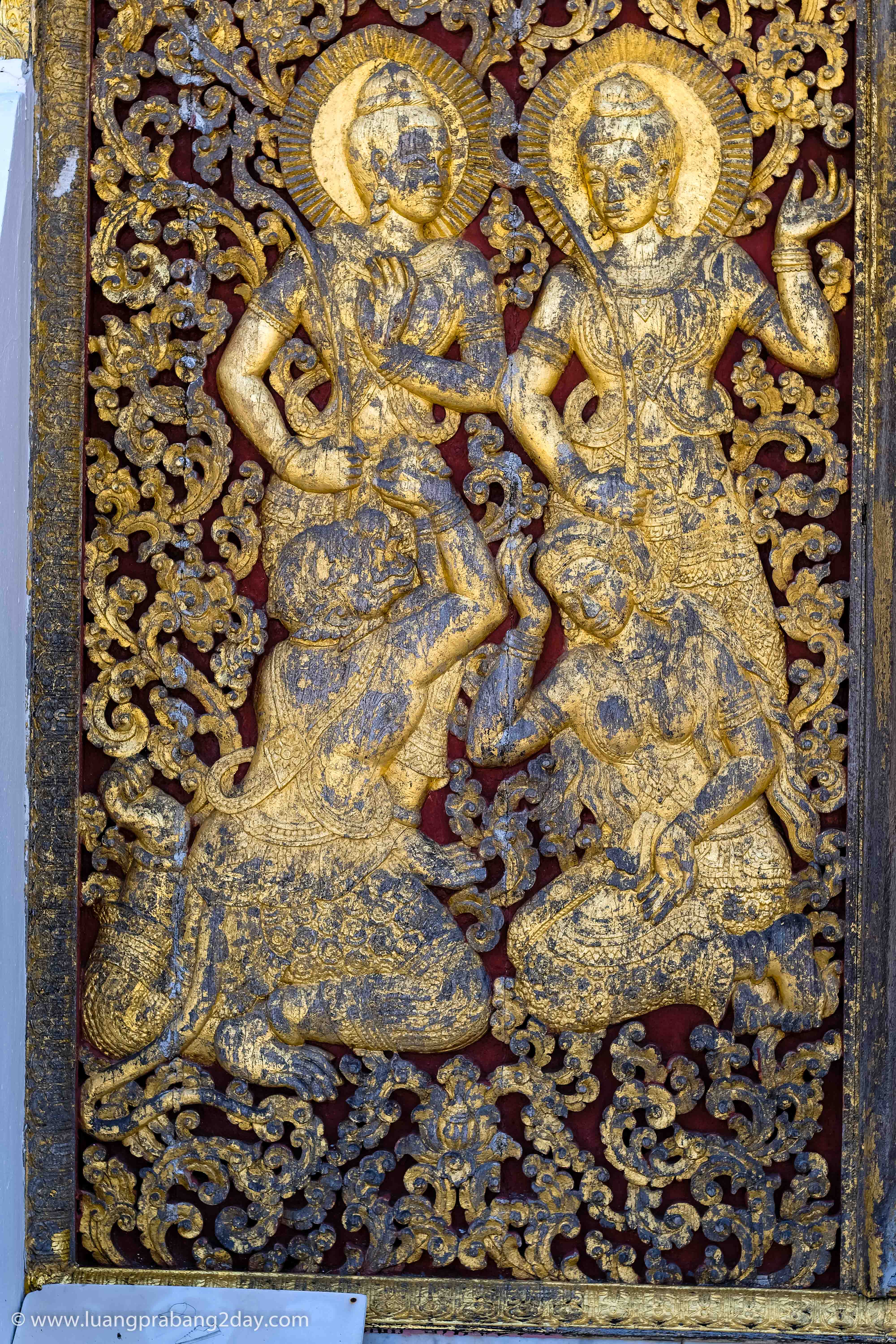 Gold leaf relief panel portraying celestial figures in traditional Lao Buddhist art at Wat Xieng Thong. Gold leaf relief panel portraying celestial figures in traditional Lao Buddhist art at Wat Xieng Thong.