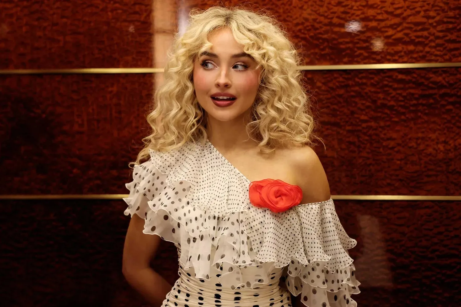 Scene from SNL's episode showing Sabrina Carpenter in a performance moment with stage lighting and styling.